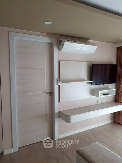 Modern living room with wall-mounted TV and air conditioning unit, featuring sleek design and neutral tones.