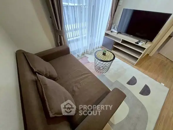 Cozy living room with modern sofa and large TV, perfect for relaxation.