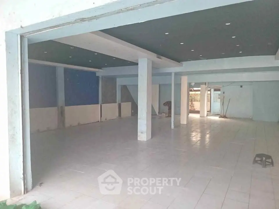 Spacious open-plan commercial space with tiled flooring and modern lighting.
