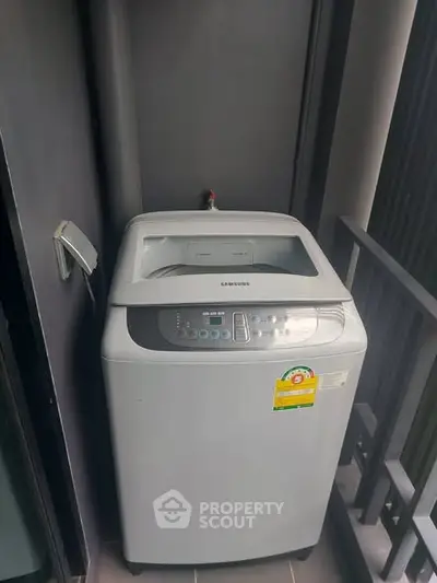 Modern washing machine on a balcony in a contemporary apartment setting.