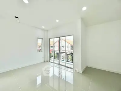 Spacious modern living room with large windows and balcony access