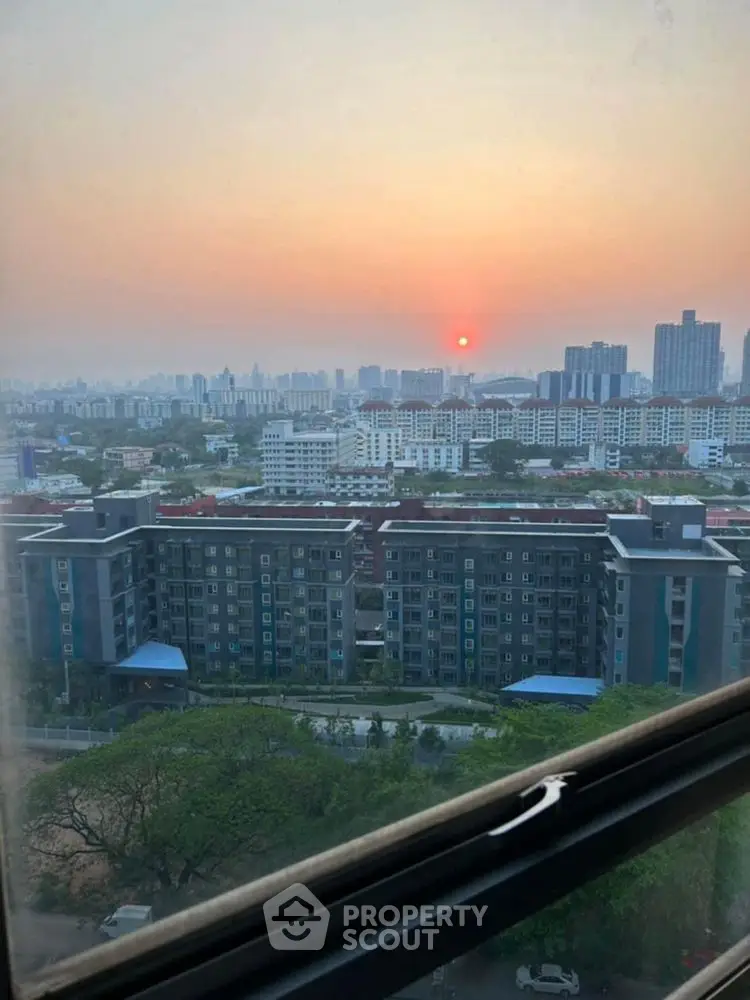 Stunning cityscape view from a high-rise window at sunset, showcasing urban skyline.