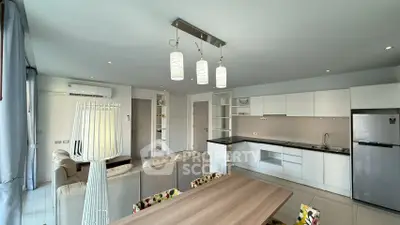 Modern open-plan living room and kitchen with sleek design and neutral tones.