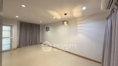 Spacious unfurnished room with modern lighting and large windows, perfect for customization.