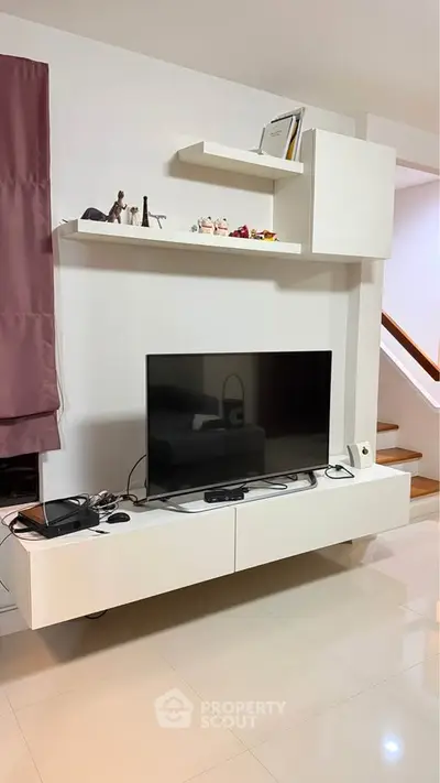 Modern living room with sleek TV unit and decorative shelves, perfect for stylish home entertainment setup.