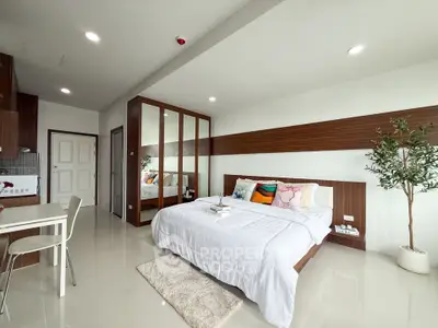 Modern bedroom with stylish decor and mirrored wardrobe in a bright apartment.