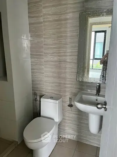 Modern bathroom with sleek fixtures and large mirror in a contemporary home.