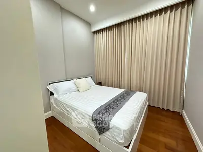Cozy bedroom with elegant decor and wooden flooring, perfect for relaxation.