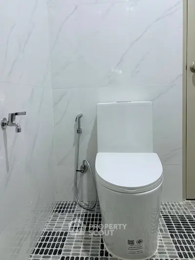 Modern bathroom with sleek toilet and bidet in minimalist design.