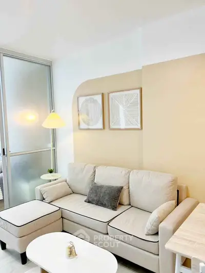 Modern living room with beige sofa, stylish decor, and natural light for a cozy ambiance.