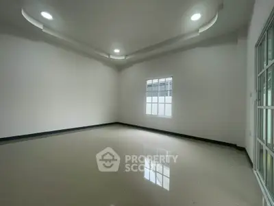 Spacious empty room with modern ceiling lights and large window