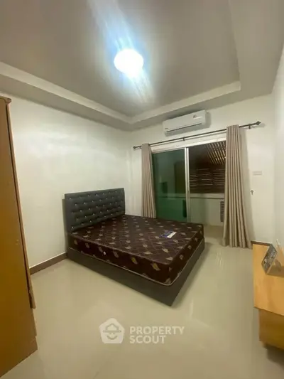 Spacious bedroom with modern decor and balcony access