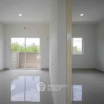 Bright and spacious interior with large windows and glossy tiled floors, perfect for modern living.