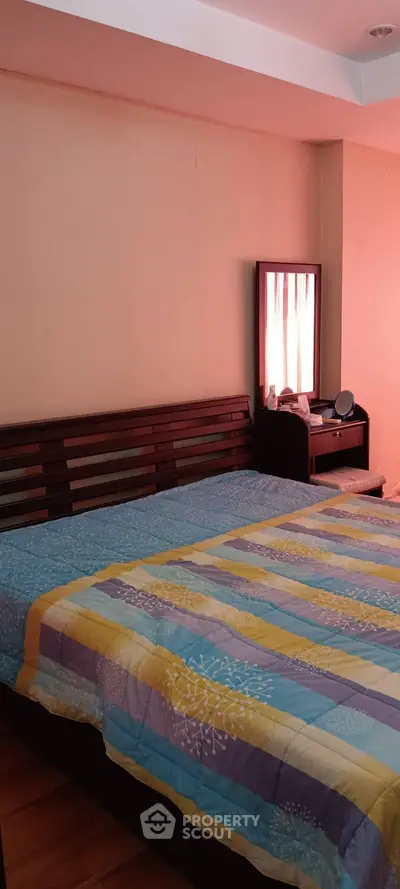 Cozy bedroom with colorful bedding and wooden furniture