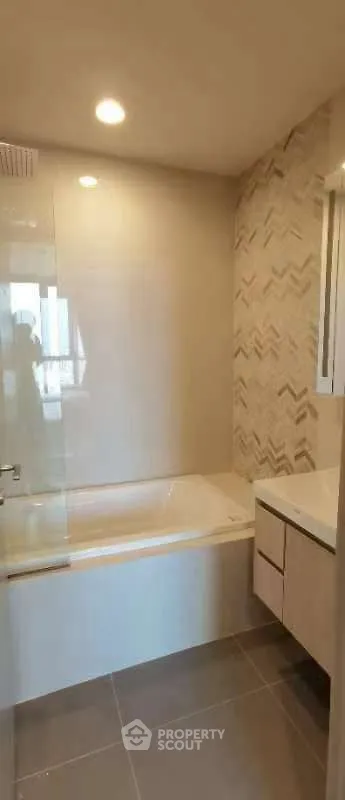 Modern bathroom with stylish tile design and built-in bathtub