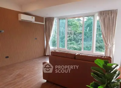 Spacious living room with large windows and scenic forest view