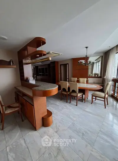 Spacious open-plan living and dining area with elegant wooden accents and large windows.