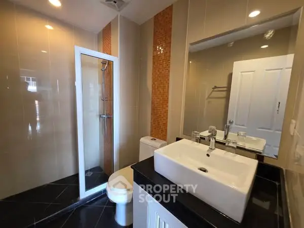 Modern bathroom with sleek fixtures and glass shower enclosure
