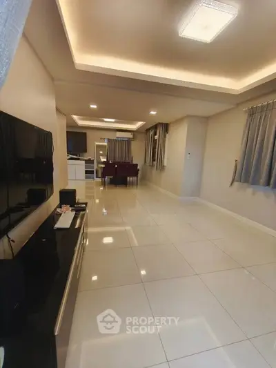 Spacious modern living room with sleek tile flooring and elegant lighting