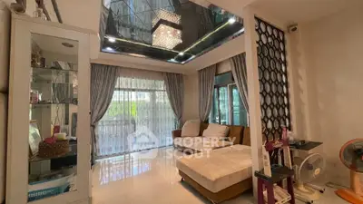 Luxurious living room with elegant chandelier and plush seating in modern home.