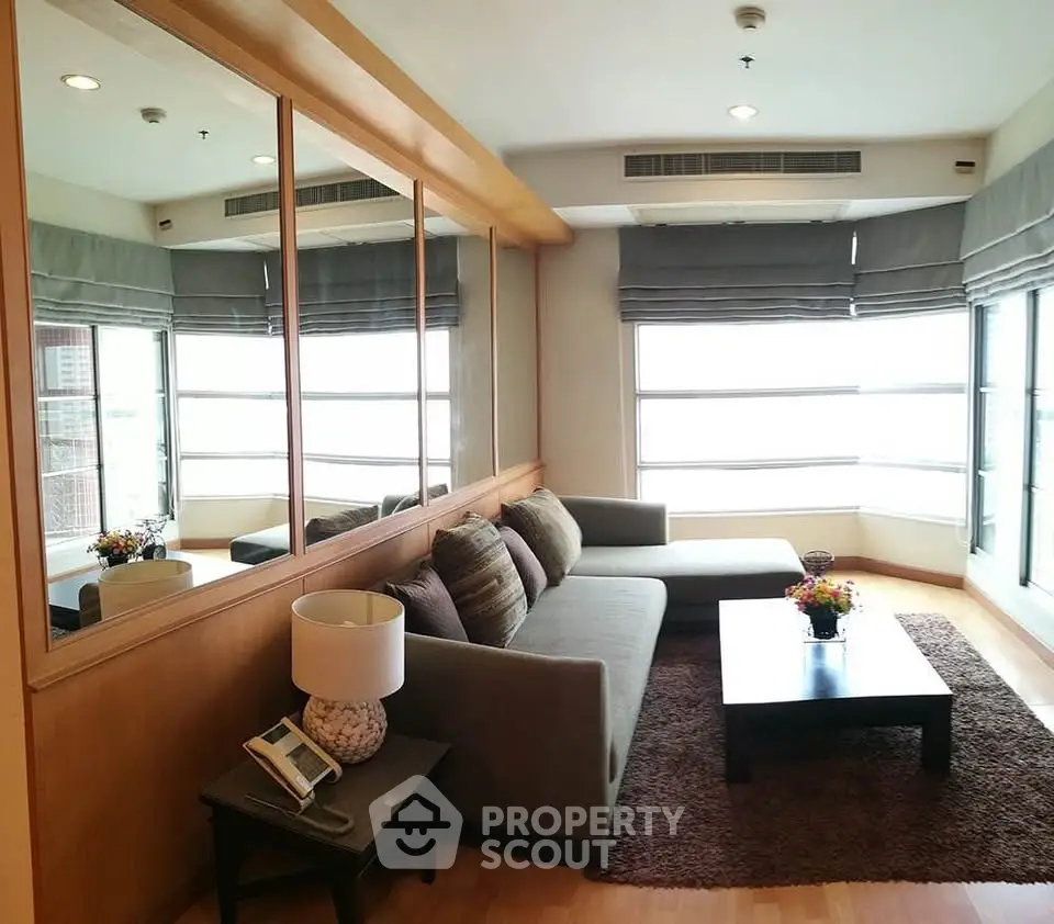 Spacious living room with large windows and modern decor in a luxury apartment.