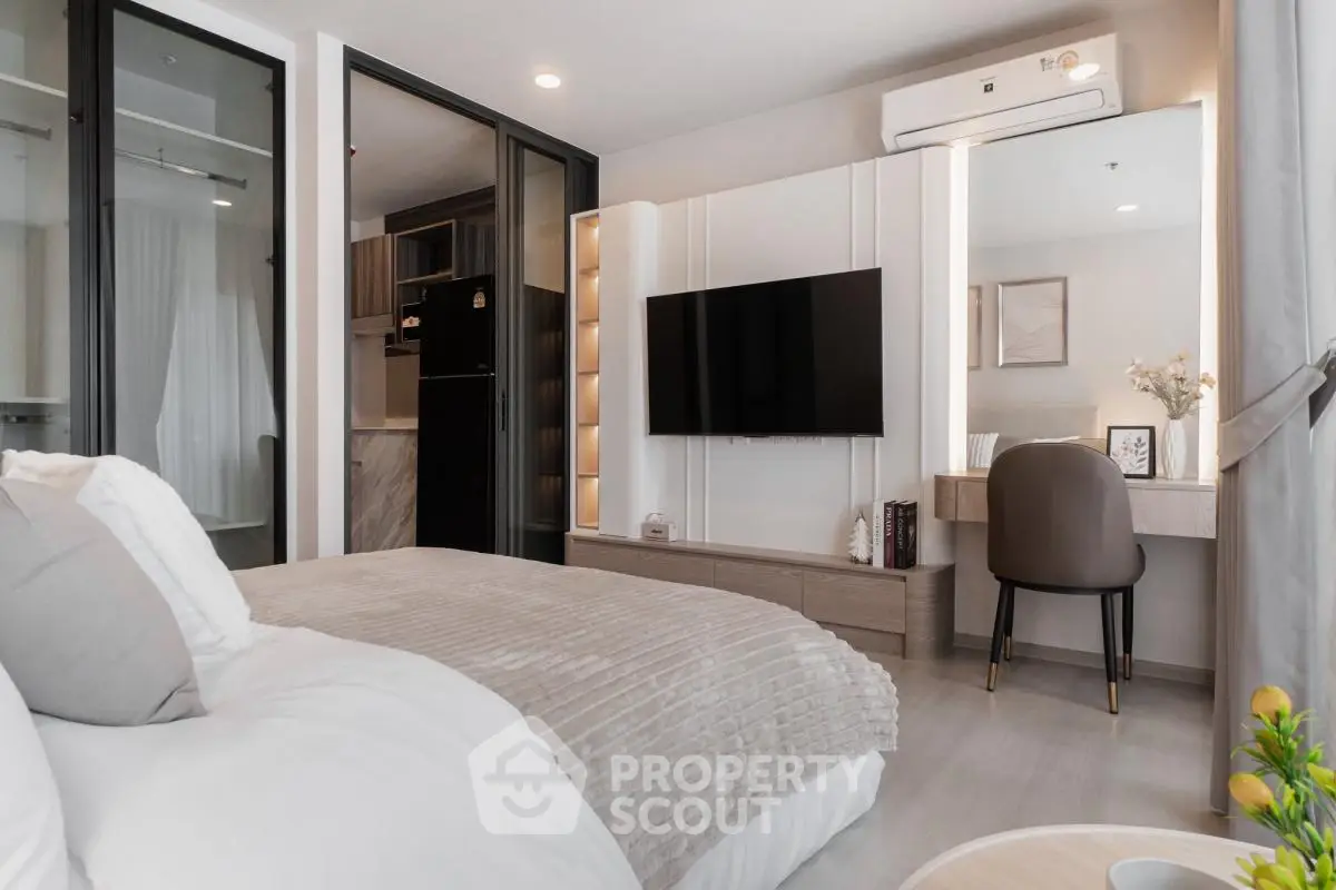 Modern bedroom with stylish decor and wall-mounted TV in a cozy apartment.