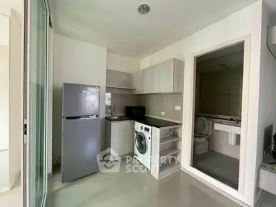 Modern compact kitchen with washing machine and fridge in a cozy apartment