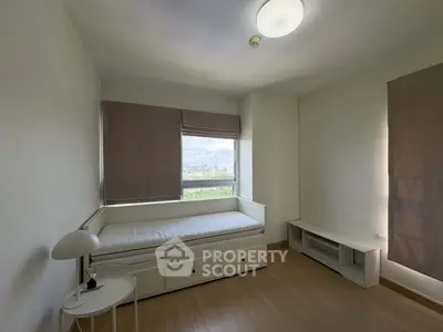 Spacious bedroom with large window and minimalist decor, offering serene views and ample natural light.