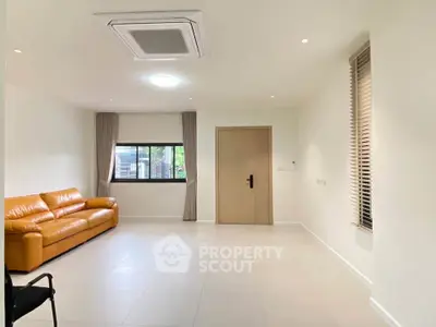 Spacious modern living room with leather sofa and large window