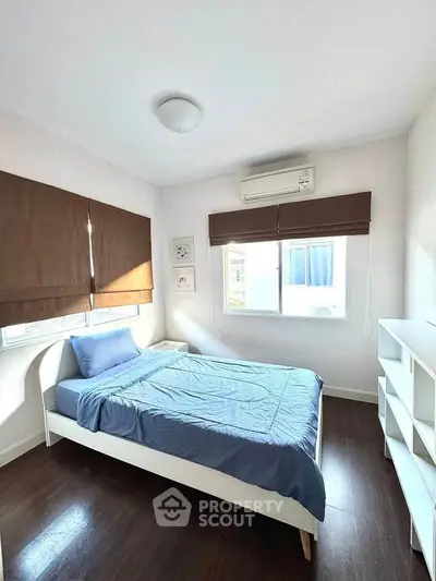 Cozy bedroom with natural light and modern furnishings, perfect for relaxation.