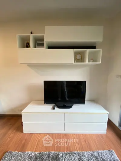 Modern living room with sleek white TV stand and wall-mounted shelves.