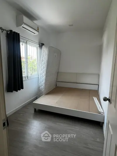 Minimalist bedroom with air conditioning and natural light