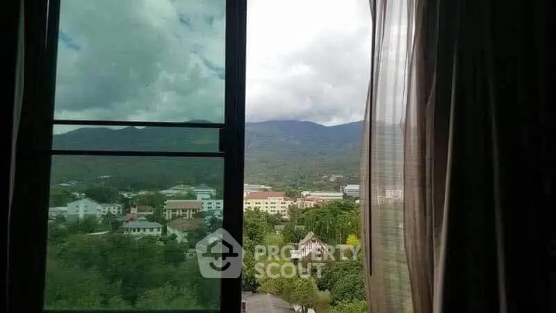 Stunning mountain view from a window, offering serene and picturesque scenery.