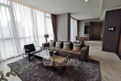 Spacious modern living room with large windows and elegant decor in a high-rise apartment.