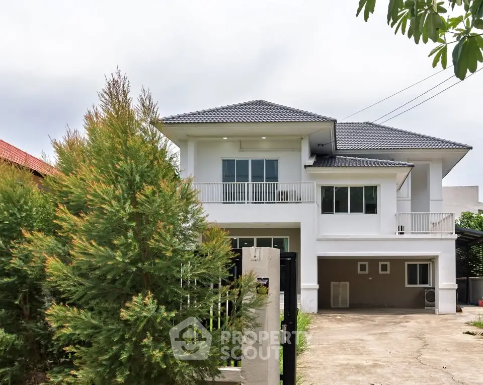 Stunning two-story modern house with spacious driveway and lush greenery.