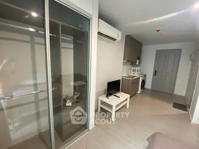 Modern apartment interior with sleek furniture and built-in appliances, featuring a compact living area and kitchen.