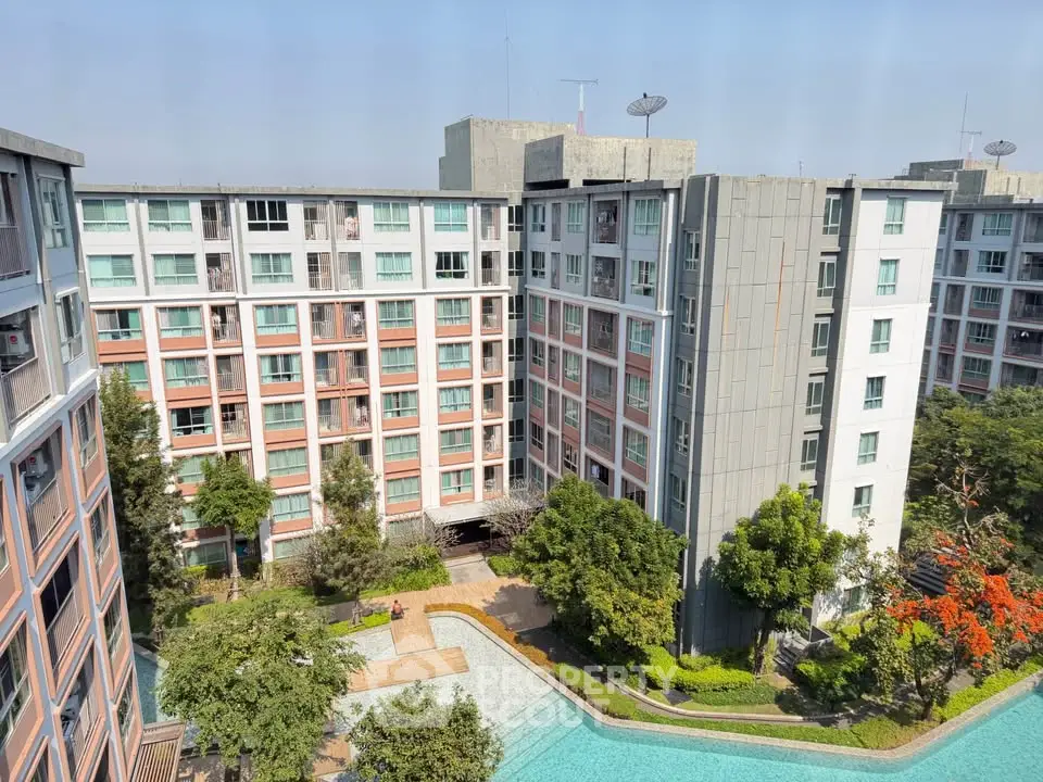 Modern apartment complex with pool and lush greenery, offering a serene urban living experience.