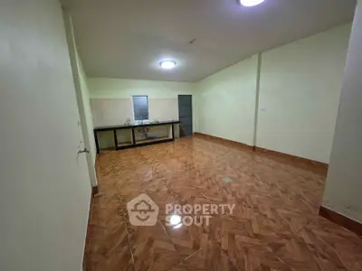 Spacious open layout room with wooden flooring and minimalist design, ideal for versatile living arrangements.