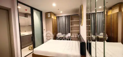 Modern studio apartment with sleek kitchen and cozy bedroom area.