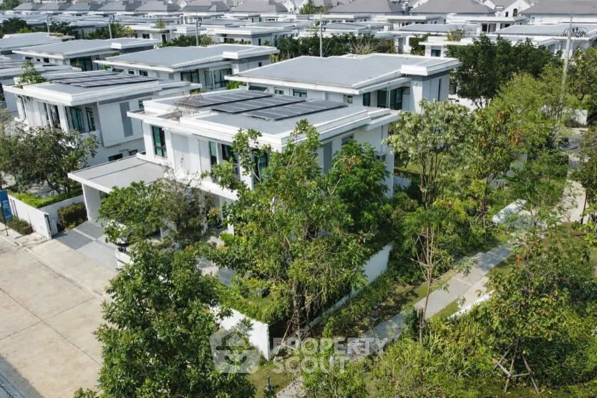Modern residential neighborhood with solar-paneled rooftops and lush greenery.