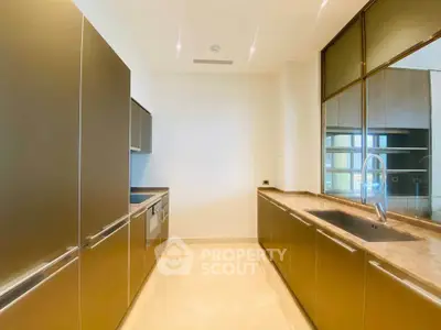 Modern kitchen with sleek cabinetry and marble countertops in luxury apartment.