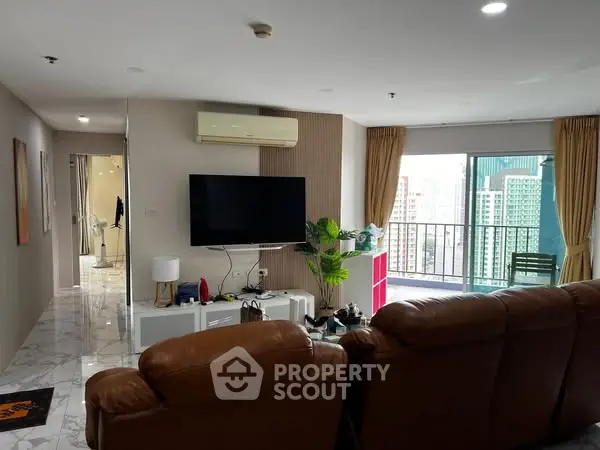 Spacious living room with city view and balcony access in modern apartment.