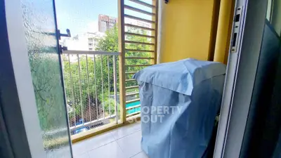 Charming balcony with city view and covered appliance, perfect for urban living.