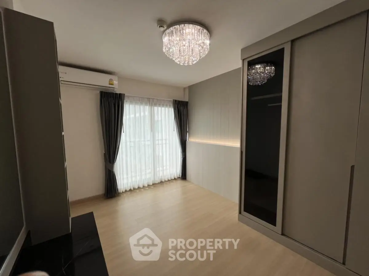 Spacious bedroom with elegant chandelier and large wardrobe