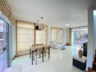 Spacious and bright living room with modern decor and large windows opening to a patio.