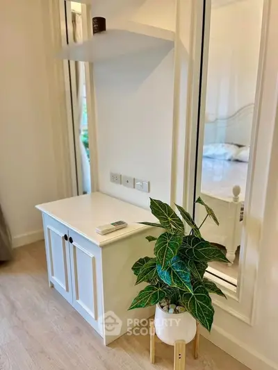 Charming bedroom corner with elegant white furniture and lush green plant