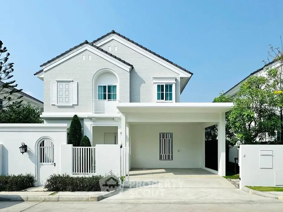 Charming white two-story house with modern design and spacious driveway in a serene neighborhood.
