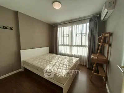Cozy bedroom with natural light and modern furnishings in a stylish apartment.