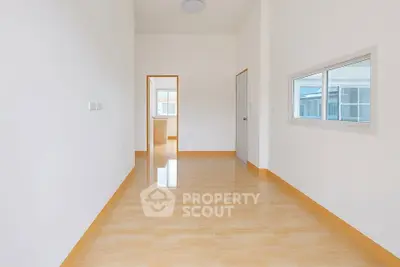 Spacious empty room with glossy tiled floor and bright natural light.