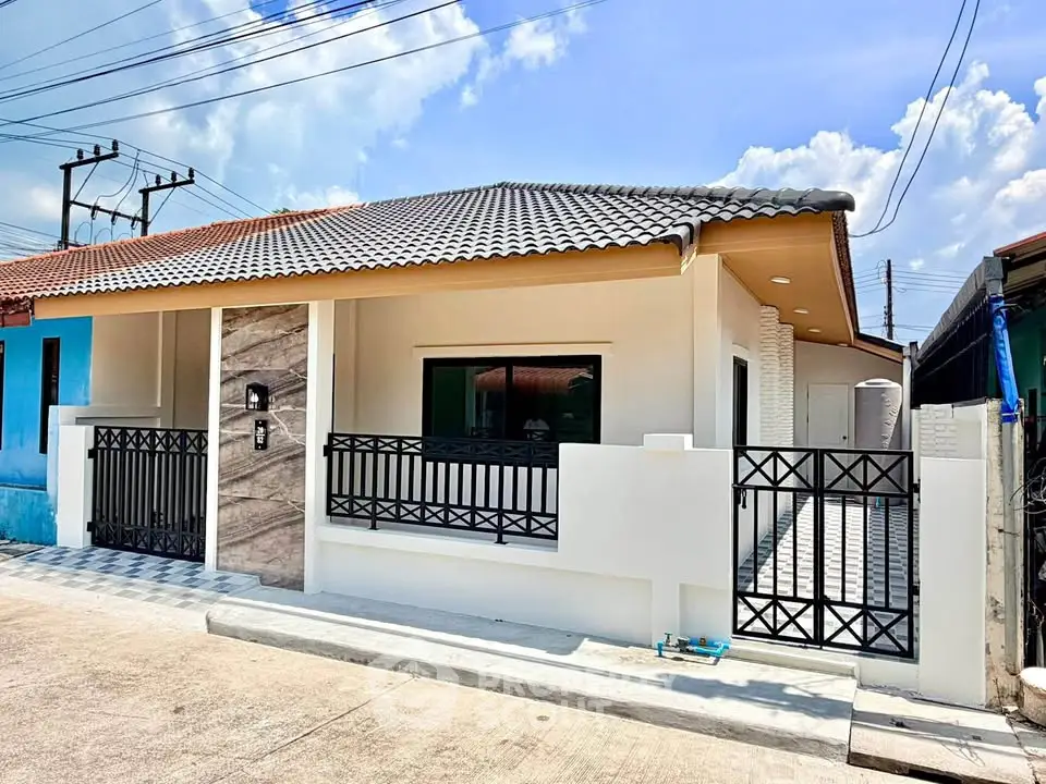Charming single-story house with modern facade and tiled roof in a sunny neighborhood.